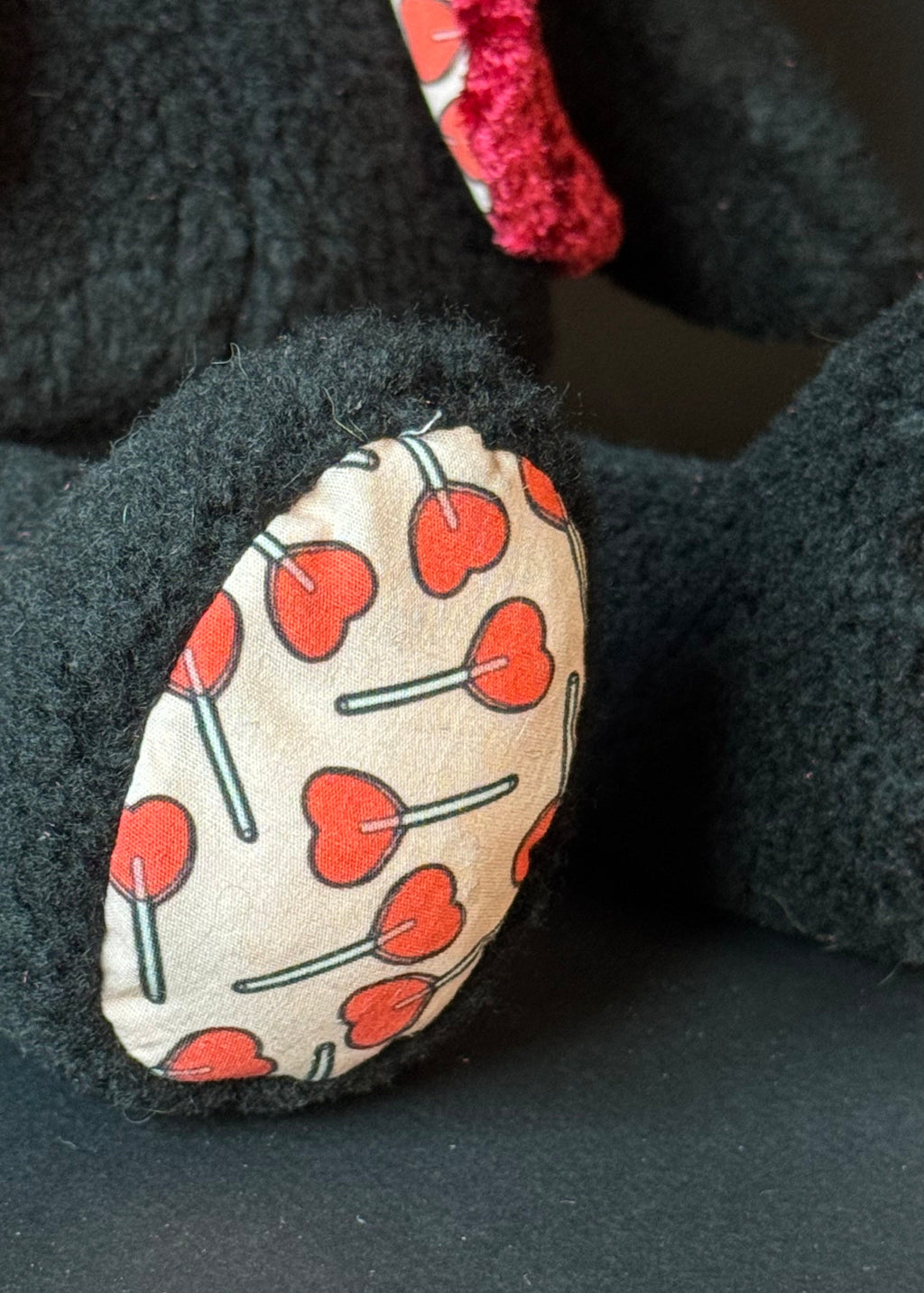 Ein Bild einer Detailaufnahme des Fußes von dem Kuscheltierhasen mit Herzlolli-Stoffmuster. 
